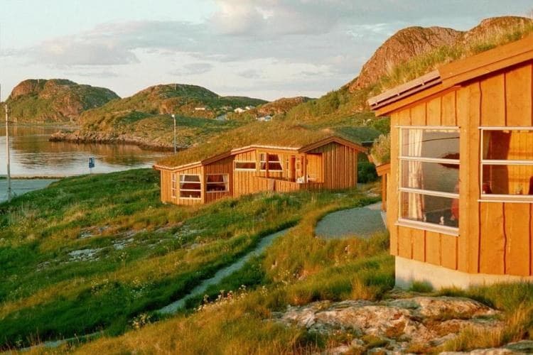 Die Ferienhäuser von Garten Sjøhus mit Grasdächern über dem Meer